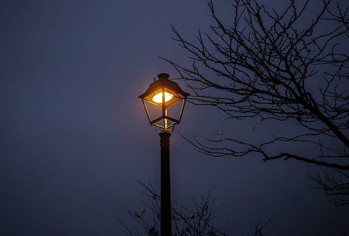 Metal old-fashioned lamppost against blue sky