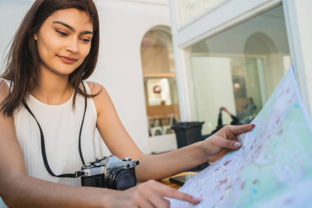 istock Young tourist woman looking at map at coffee shop. 1292632012