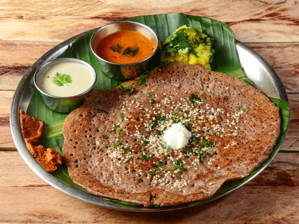 ragi dosa 或手指小米多薩南印度傳統早餐， 配甜甜圈， 桑巴和土豆瑪薩拉加黃油， 在質樸的木製背景上供應， 選擇性的焦點 - ryan in a 個照片及圖片檔