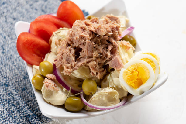 салат из тунца с картофелем и вареным яйцом называется nicoise на белом фоне - tuna prepared fish mayonnaise restaurant стоковые фото и изображения