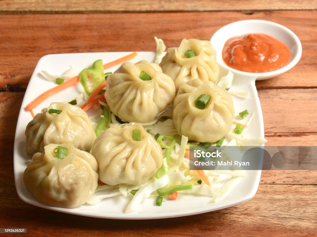 Veg steam momo. Nepalese Traditional dish Momo stuffed with vegetables and then cooked and served with sauce over a rustic wooden background, selective focus Dumpling Stock Photo
