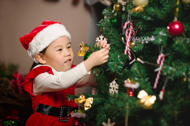 istock young girl decorating Christmas tree at home 1292635361