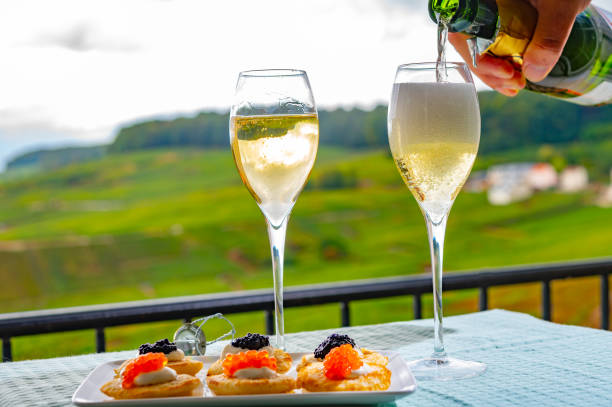 Tasting of french sparkling white wine with bubbles champagne on outdoor terrace with view on grand cru Champagne vineyards in Cramant, near Epernay, France Tasting of french sparkling white wine with bubbles champagne on outdoor terrace with view on green grand cru Champagne vineyards in Cramant, near Epernay, France cramant stock pictures, royalty-free photos & images