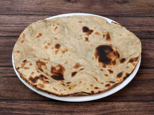 istock Tandoori Roti, isolated over a rustic wooden background, selective focus 1292638301