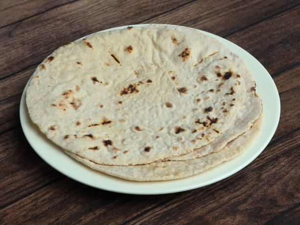 istock Tandoori Roti, isolated over a rustic wooden background, selective focus 1292638311