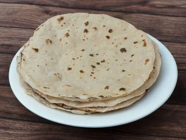 Chapati, isolated over a rustic wooden background, selective focus