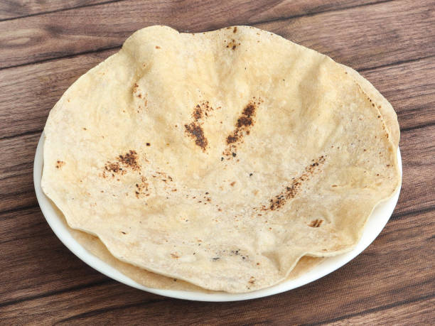 istock Chapati, isolated over a rustic wooden background, selective focus 1292638385
