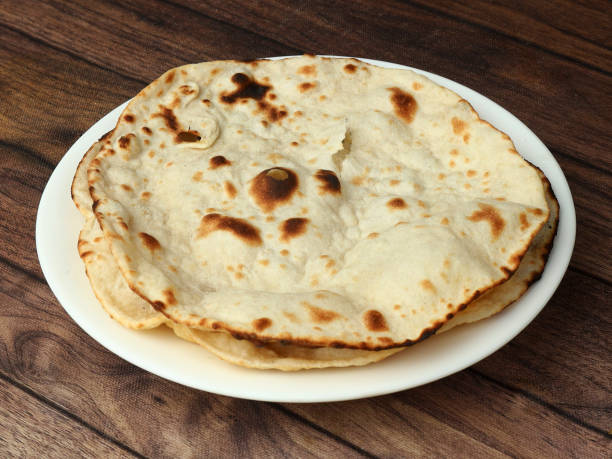 istock Tandoori Roti, isolated over a rustic wooden background, selective focus 1292638392