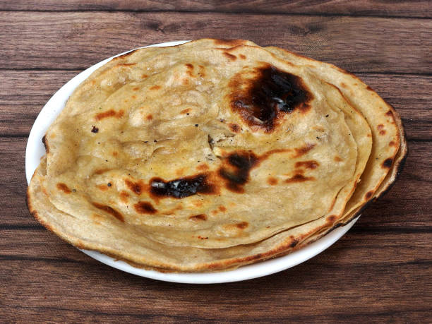 istock Lachha Paratha, a layered flat bread using wheat flour, popular dish in north India. isolated over a rustic wooden background, selective focus 1292638449