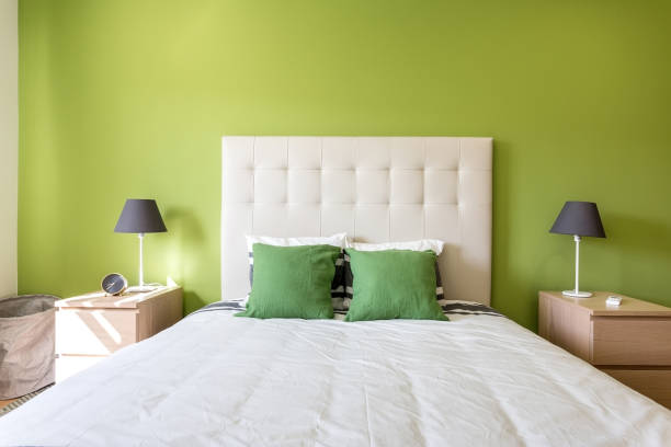 Modern bedroom in white and green colors. European hotel design and inside. stock photo