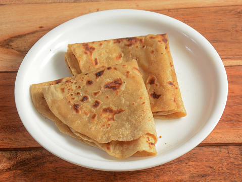 Chapati, isolated over a rustic wooden background, selective focus