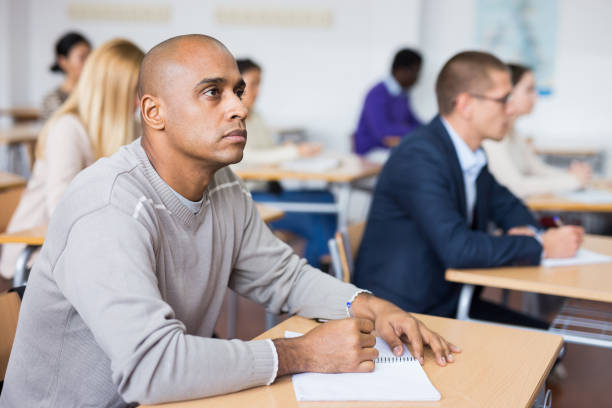 istock Portrait of a student at a desk in university audience 1292641410