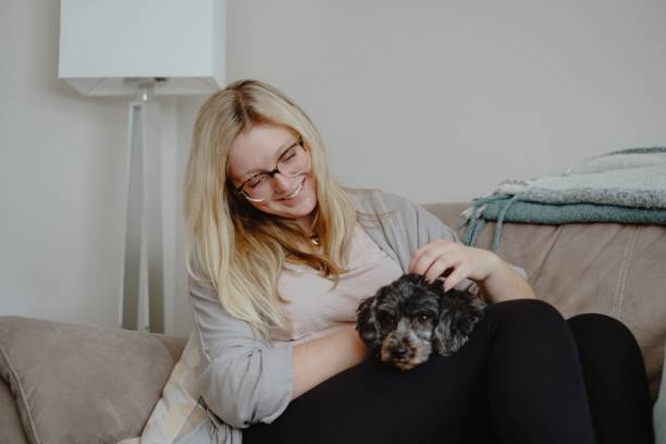 istock Woman cuddles with dog on couch 1292642635