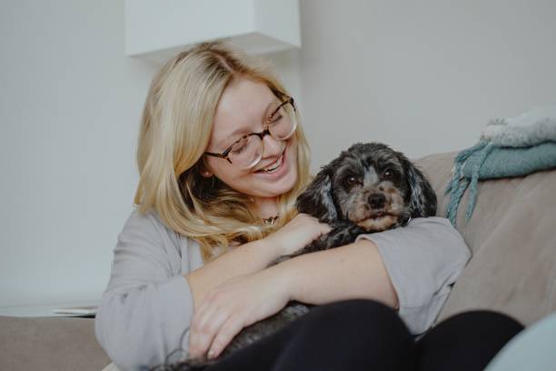istock Woman cuddles with dog on couch 1292642667
