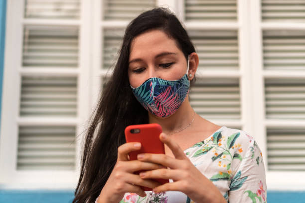 istock Girl with a mask using the smartphone 1292642753