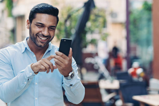 istock Cheerful man using mobile phone on the street 1292644183