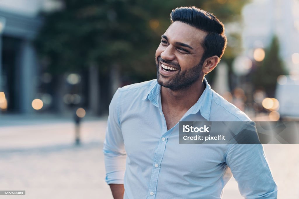Smiling young man outdoors in the city Smiling young man walking outdoors Men Stock Photo