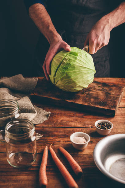 Preparing White Cabbage Man is Preparing White Cabbage for Dinner white cabbage stock pictures, royalty-free photos & images