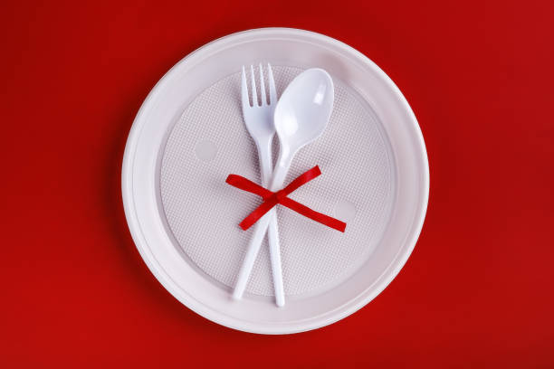istock Top view of plastic white disposable fork and spoon tied with red ribbon 1292651368