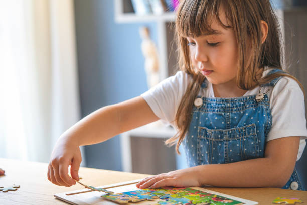 istock Little girl playing with puzzles at home 1292652223