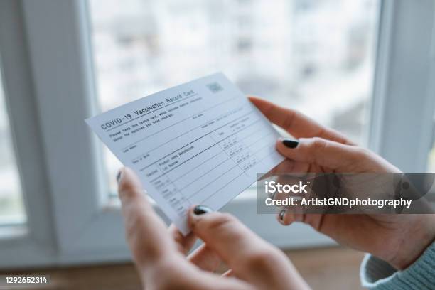 Woman Holding Covid19 Vaccination Record Card Stock Photo - Download Image Now - Immunization Certificate, COVID-19 Vaccine, Vaccination