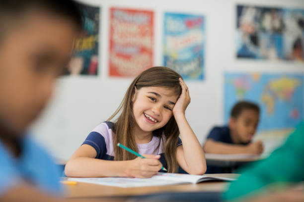 istock Caucasian girl student in classroom writing 1292652394