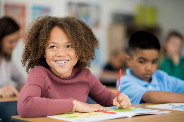 istock Adorable African American elementary school girl in classroom 1292652398