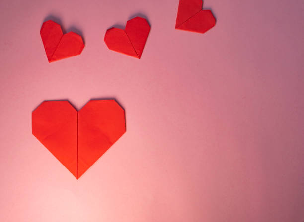 istock Origami red hearts on pink background 1292660124