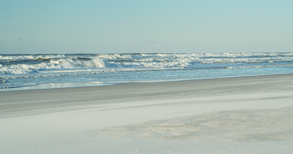 Waves crashing on the white sand of Grayton Beach in Walton County, Florida at sunrise.