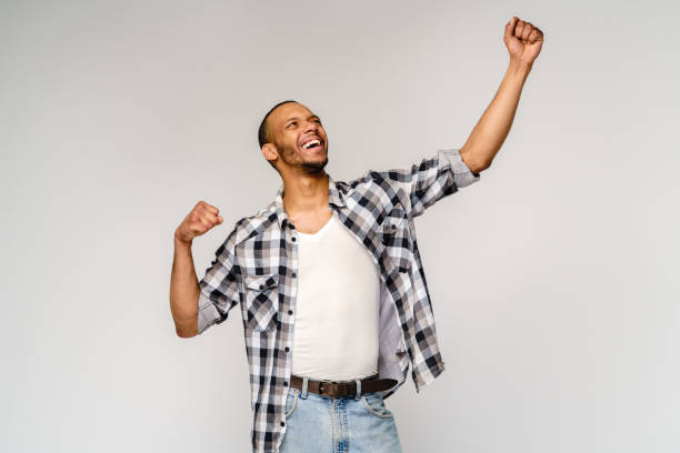 istock Young African-American man yes win gesturing over light grey background 1292663895