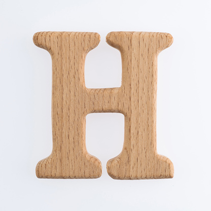 Wooden letter H on white background.