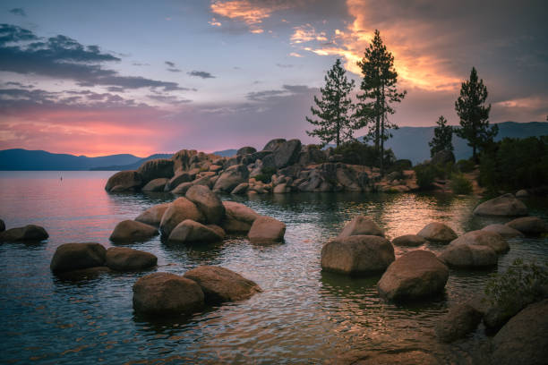 Sunset Over Lake Tahoe A mesmerizing sunset drapes this iconic Lake Tahoe landscape in a beautiful range of colors on this warm summer evening. This sunset remains one of my fondest memories as I gazed peacefully over the lake, watching the day give its last goodbyes. nevada landscape stock pictures, royalty-free photos & images