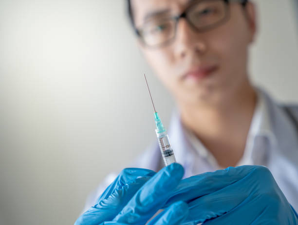 istock Asian Medical People Holding Syringe 1292668873