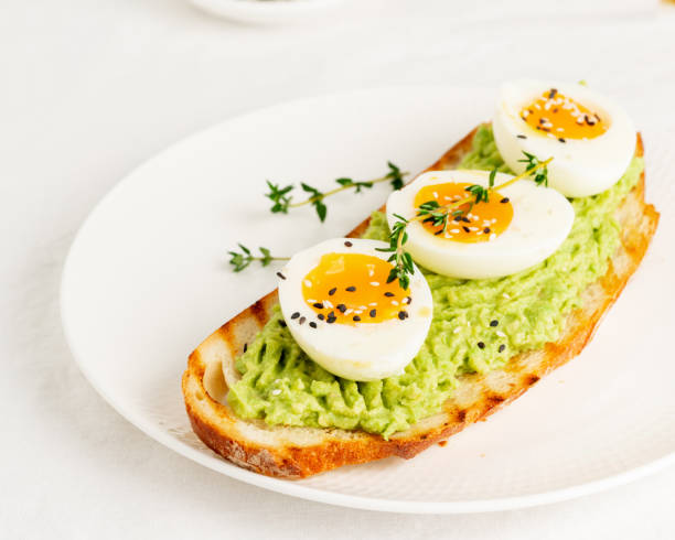 istock Avocado toast with toasted bread soft-boiled eggs with herbs 1292678341