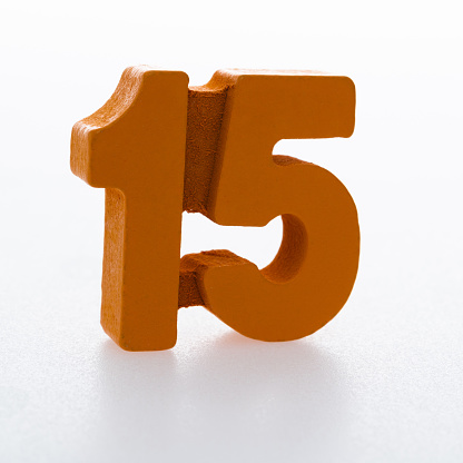 Wooden number 15 on white background.