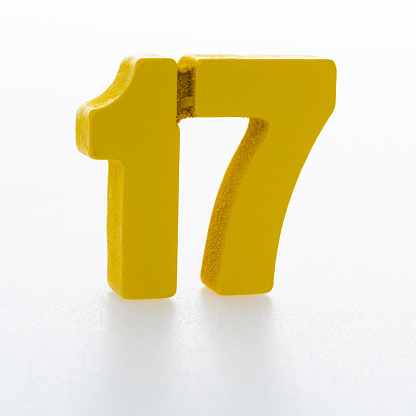 Wooden number 17 on white background.