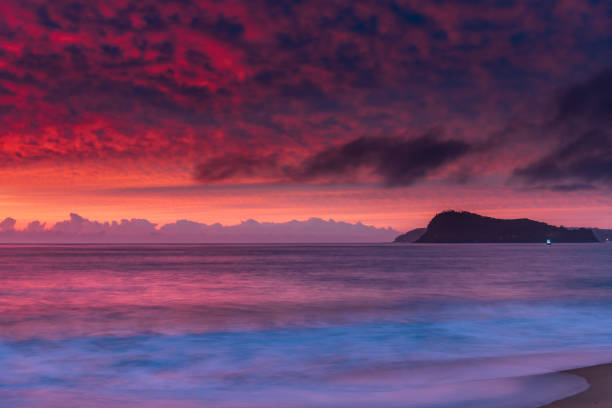 Colourful sunrise seascape with high cloud filled sky from North Pearl Beach on the Central Coast, NSW, Australia.