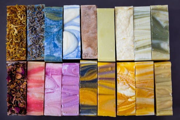 Collection of natural handmade colorful bathroom bars of soap side by side in a row. Homemade Beauty Products with natural colorful oils from plants and flowers. Different colors, textures, scents and flavours. Shot from directly above.