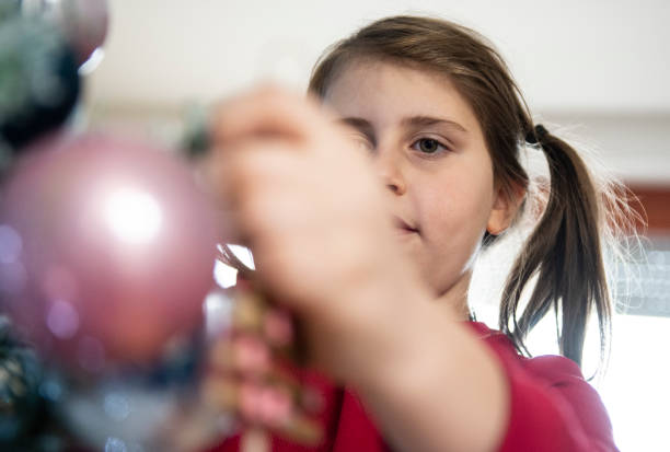 istock Little Girl Decorating Christmas Tree with Ornaments 1292686803