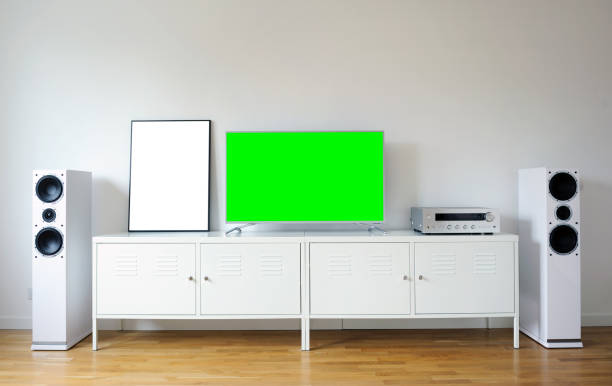 istock Widescreen modern green screen TV for text and video on a chrome stand against a white wall. 1292688764