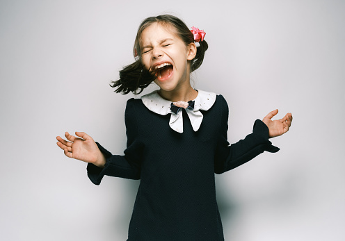 A child girl open her mouth and show her tounge, the concept of dentistry, orthodontics.