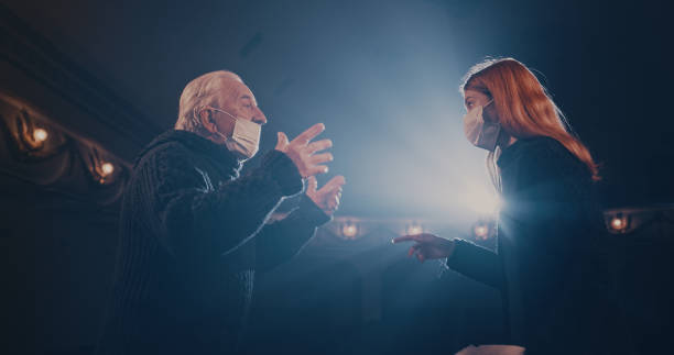 istock Actors in masks quarreling on stage in spotlight 1292689634