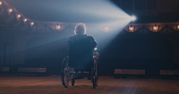 Senior actor on wheelchair leaving stage