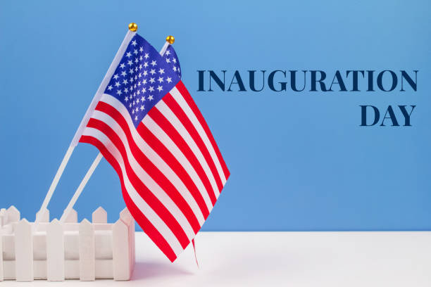 istock USA flags on white table against blue wall background, copyspace for your text. Inauguration Day 2021 concept 1292691410