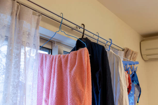部屋のカーテンレールに洗濯物をぶら下げる - 乾燥 ストックフォトと画像