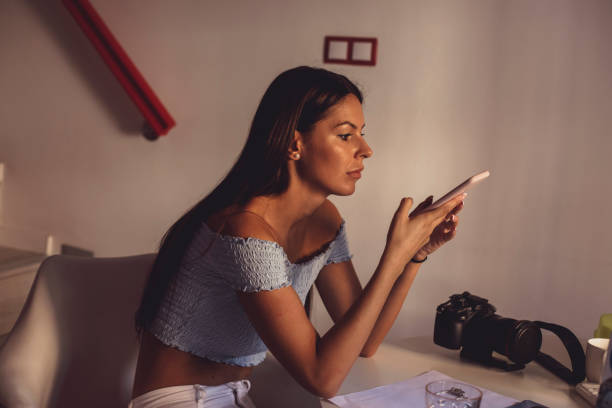 istock Young woman sitting at the table and using her smart phone 1292699439