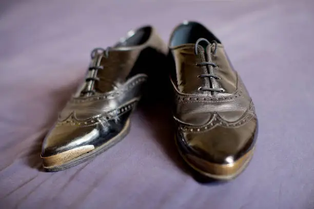 Pair of ladies black leather wingtip shoes ready to be worn by woman on her same sex wedding day
