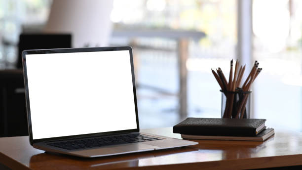 istock Mockup image of a tablet computer with blank screen, stationery and notebooks on wooden table 1292702185