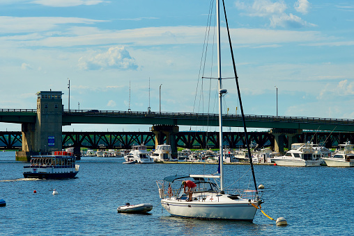 View over the water of Mount Hope Bay towards two-lane suspension Mount Hope Bridge in Rhode Island, USA connecting Portsmouth and Bristol over Route 114