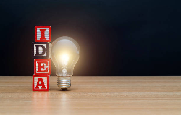 istock Light bulb and wooden word idea on the table 1292703152